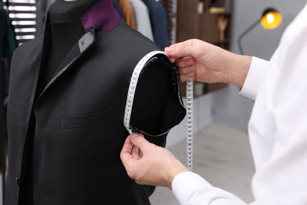 Tailor measuring a suit jacket sleeve for alterations